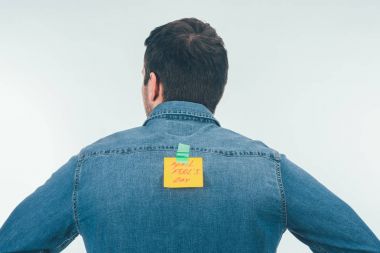 back view of man with note on sticky tape with april fools day lettering on back, april fools day holiday concept clipart