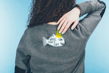 back view of woman with hand drawn fish on back, april fools day concept clipart