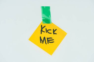 close up view of note with kick me lettering and sticky tape isolated on grey, april fools day concept clipart