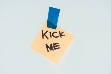 close up view of note with kick me lettering and sticky tape isolated on grey, april fools day concept clipart