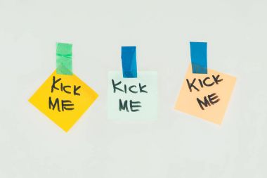 close up view of notes with kick me lettering and sticky tape isolated on grey, april fools day holiday concept clipart
