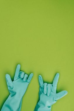 cropped image of woman showing rock signs in rubber protective gloves isolated on green clipart