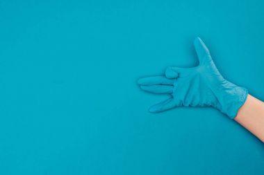 cropped image of woman showing sign with hand in rubber protective glove isolated on blue clipart