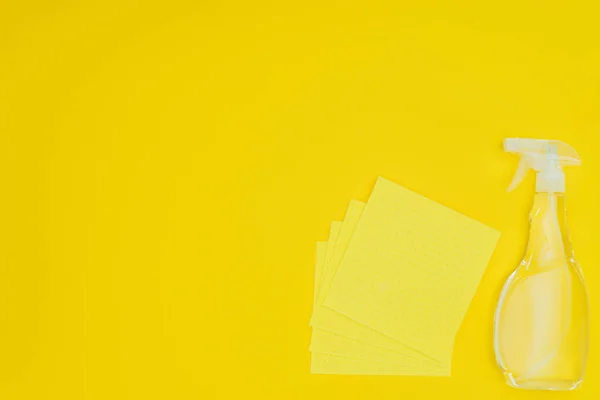 stock image elevated view of yellow rags and spray bottle isolated on yellow