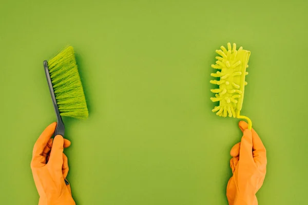 グリーン上で分離の手に つの異なる洗浄ブラシを保持している女性のトリミングされた画像 — ストック写真