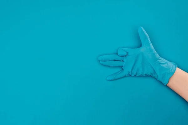在蓝色的橡胶防护手套上显示有手牌的妇女的裁剪图像 — 图库照片