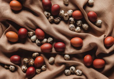 Üstten Görünüm Paskalya yumurta ve bıldırcın yumurtası keten masa örtüsü üzerinde boyalı