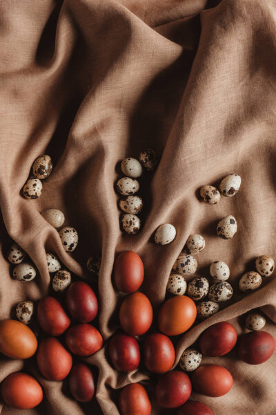 food composition with easter chicken eggs and quail eggs on linen tablecloth