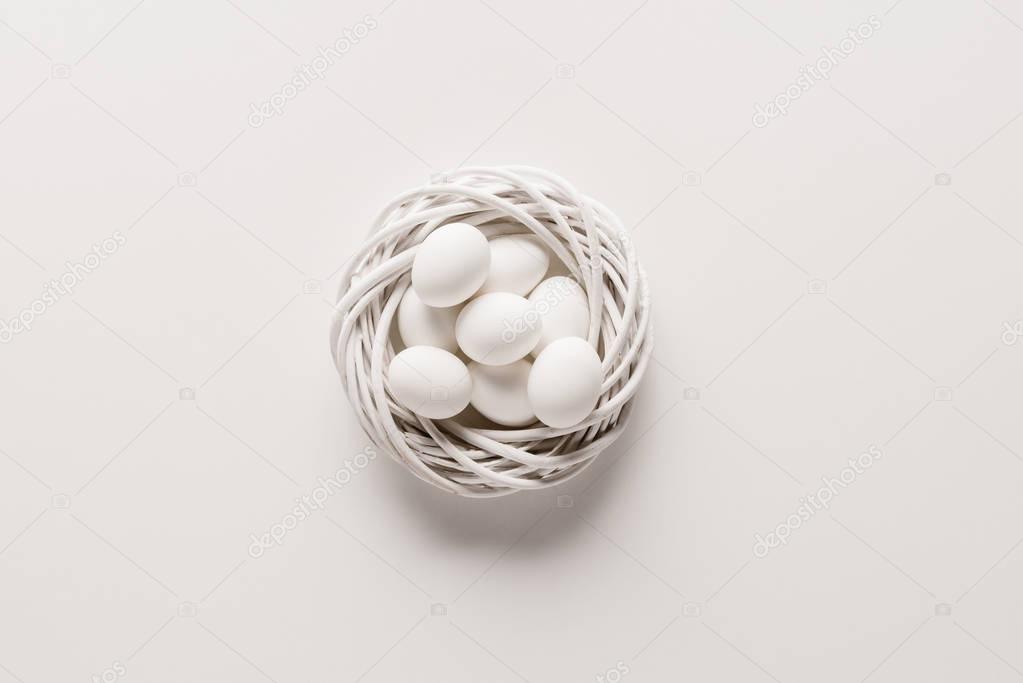 white chicken eggs in easter wreath on white background
