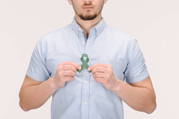 partial view of man with green awareness ribbon for Adrenal Cancer, Aging research awareness, BiPolar Disorder isolated on white