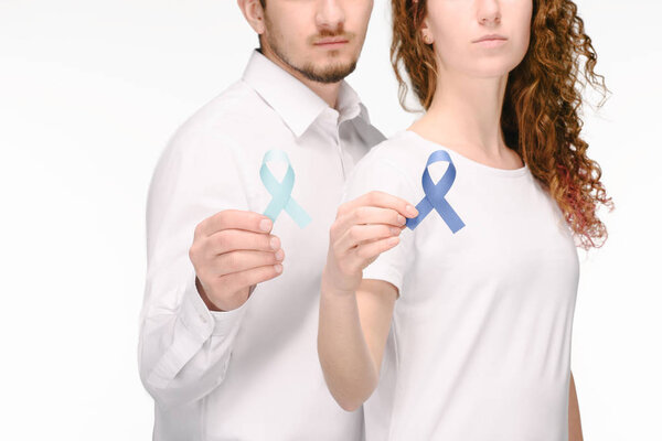 partial view of couple holding ribbons of different colors isolated on white, colon cancer concept