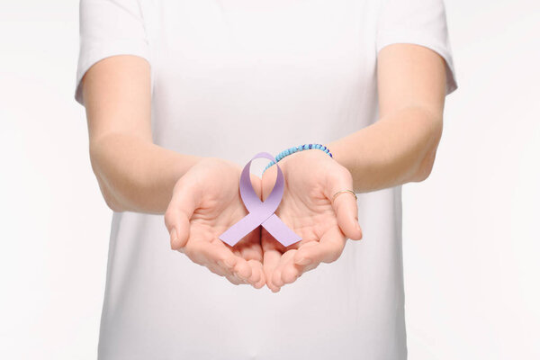 cropped shot of woman holding purple awareness ribbon for general cancer awareness, Lupus awareness, drug overdose, domestic violence symbol in hands isolated on white