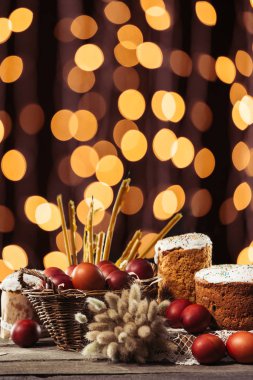 Kedicikler, mumlar, Paskalya kek ve boyalı tavuk yumurtası bokeh arka plan ahşap tablo 