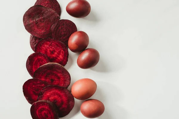 棕色彩绘复活节彩蛋和甜菜根片的最高视图灰色 — 图库照片