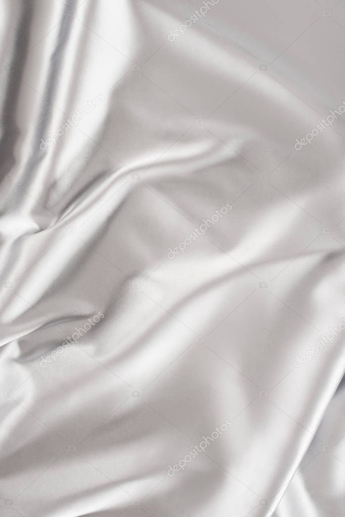 light silver crumpled shiny silk fabric background