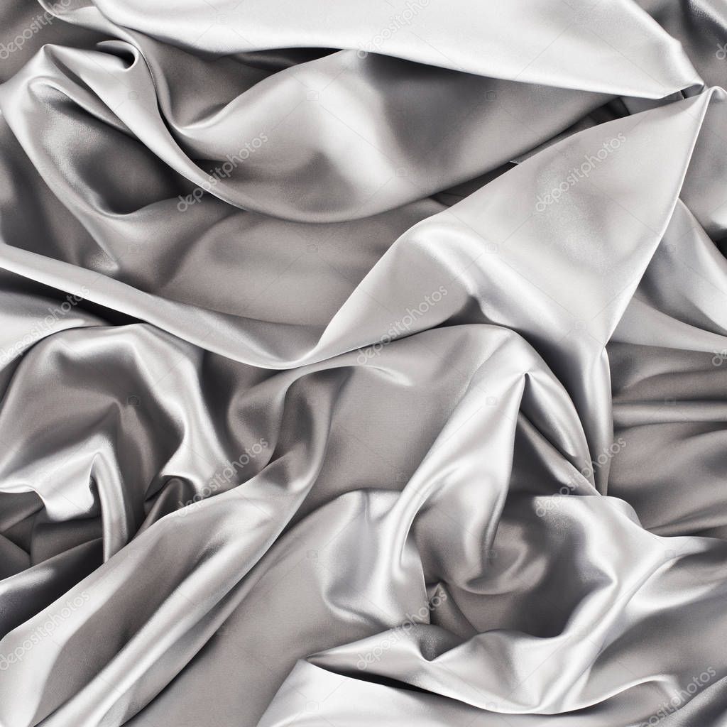 silver crumpled shiny silk fabric background