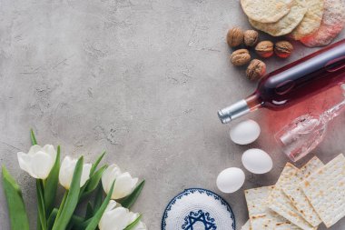 top view of tulips, kippah and matza on concrete table, jewish Passover holiday concept clipart