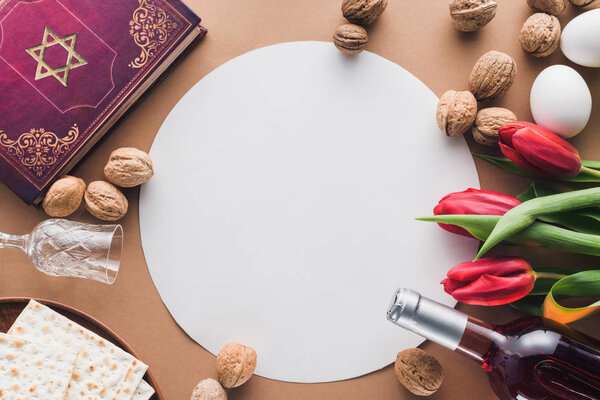 top view of traditional book with text in hebrew and blank placard on table