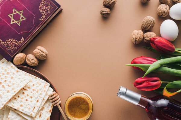 top view of traditional book with text in hebrew, wine and matza on tabletop