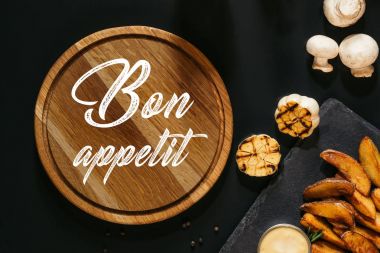 ahşap tahta yazıt Afiyet olsun, kızarmış sarımsak, mantar ve siyah soslu fırında patates