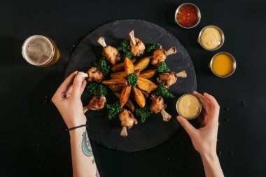 lezzetli fırında patates kızarmış tavuk ve soslar ile siyah yemek kişinin kırpılmış atış