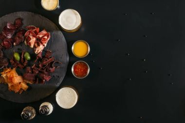 siyah lezzetli dilimlenmiş çeşitli et, bira, soslar ve baharat gözlük Üstten Görünüm