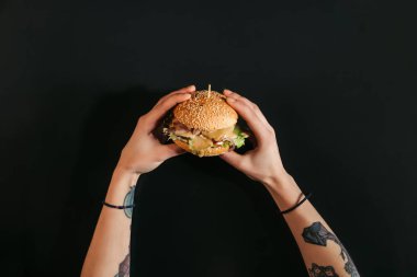 dövmeli lezzetli burger Türkiye ve sebze siyah üzerinde tutan eller kısmi Üstten Görünüm
