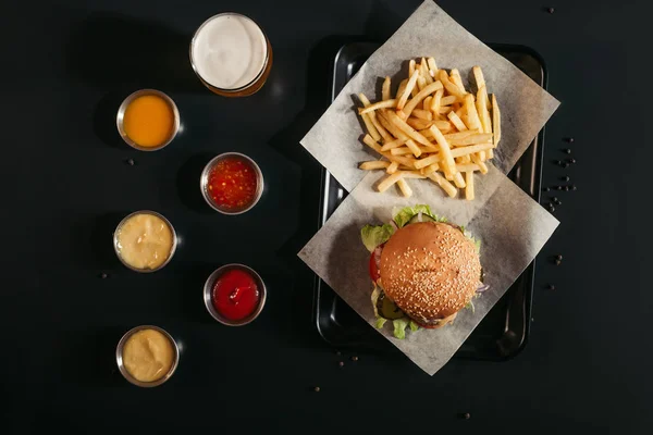 Felülnézet Ízletes Burger Hasábburgonyával Tálca Pohár Sört Válogatott Mártások Fekete — Stock Fotó