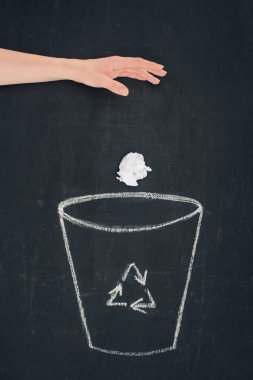 cropped shot of woman throwing crumpled paper into drawn trash bin with recycle sign on chalkboard clipart