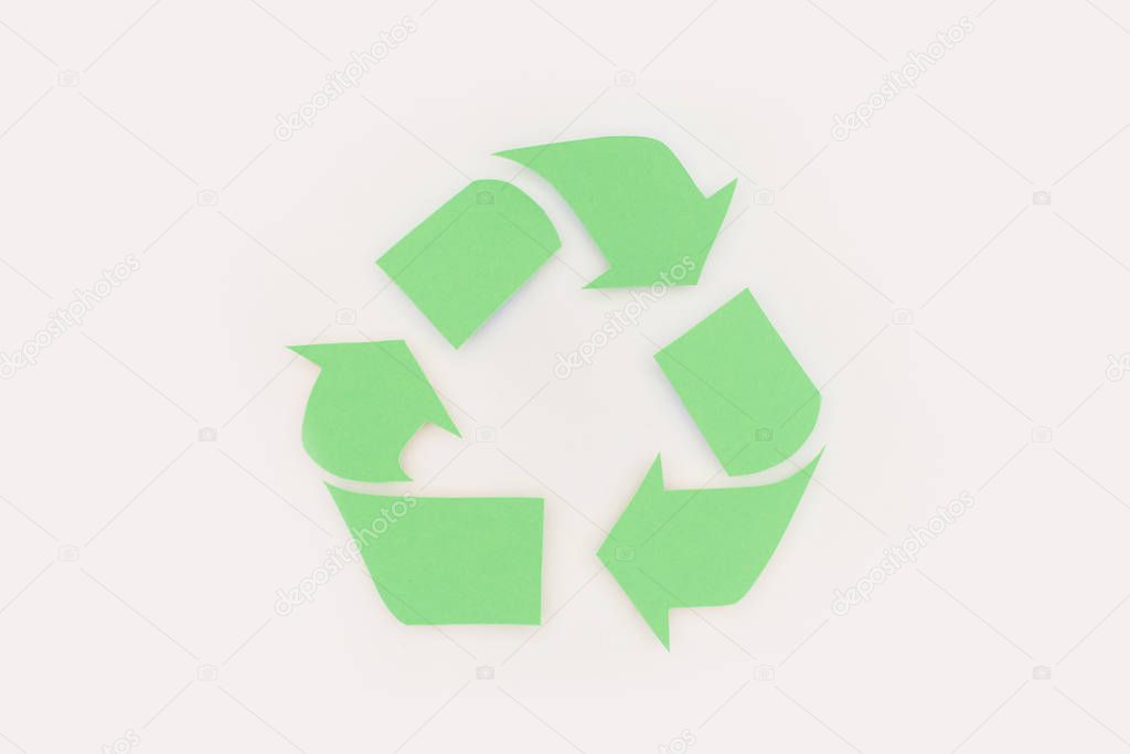 top view of green arrows recycle sign on white