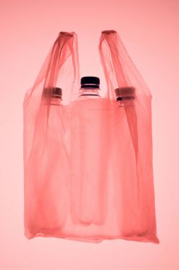 transparent plastic bag with plastic bottles under pastel pink toned light clipart
