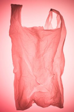 pastel pembe tonda ışık altında buruşuk plastik torba