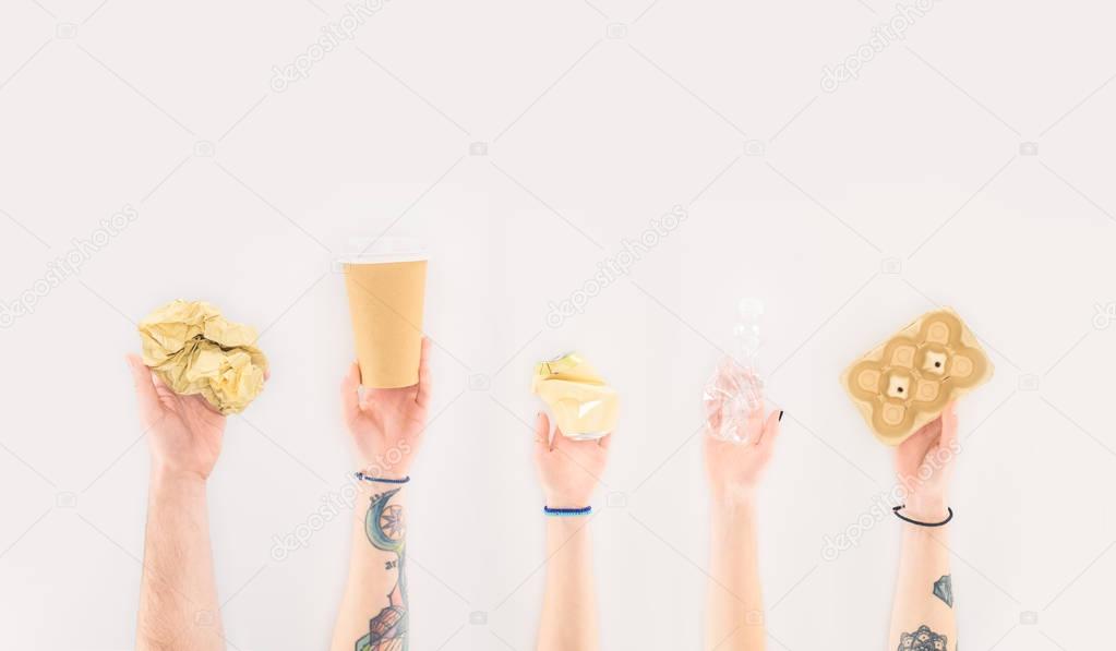 cropped shot of people holding various paper trash isolated on white