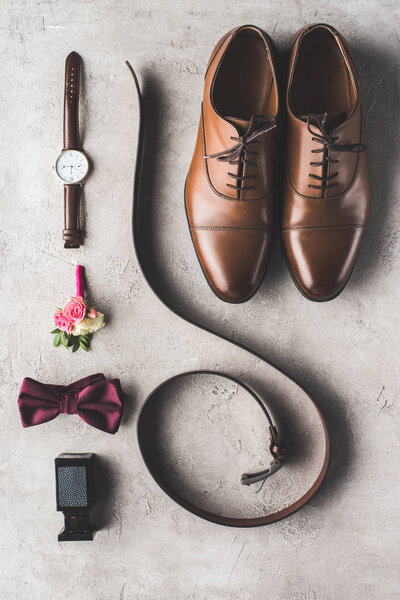 elevated view of male wedding accessories for groom on gray surface