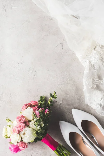 灰色の表面上のウェディング ドレス 花束のトップ ビュー — ストック写真