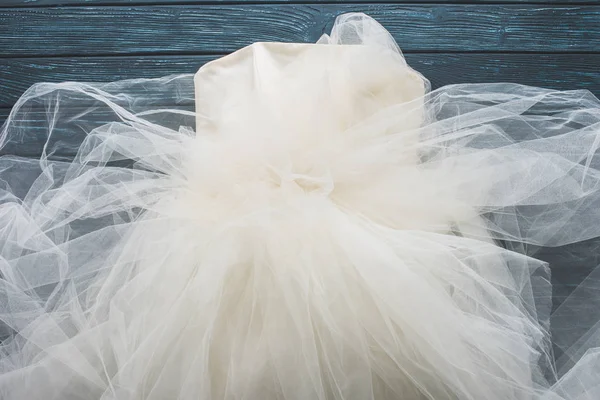 在木质深蓝桌面上的婚纱礼服的顶级视图 — 图库照片