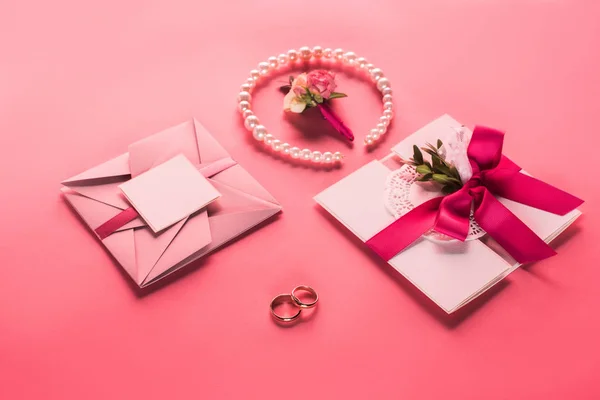 Trouwringen Parel Ketting Corsages Roze Enveloppen Met Uitnodigingen Roze Oppervlak — Stockfoto