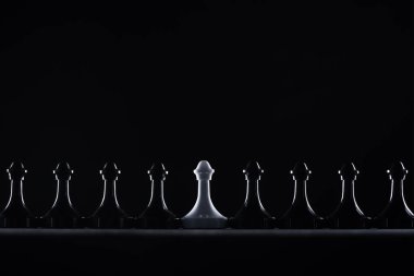 silhouettes of black and white chess pawns isolated on black, business concept clipart