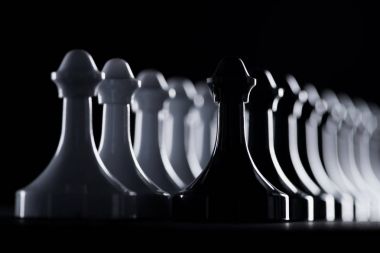 rows of white and black chess figures isolated on black, business concept clipart