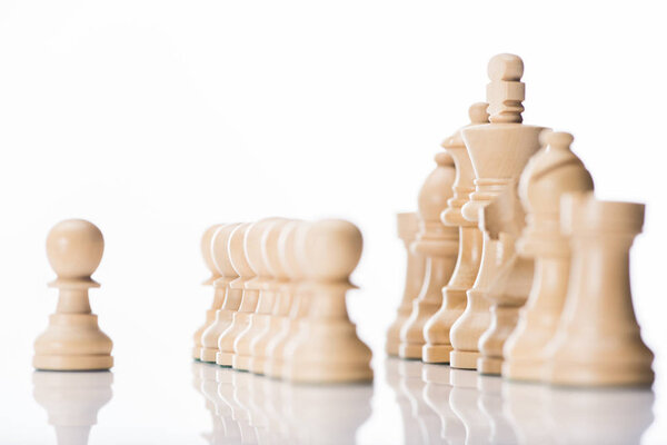 белые шахматные фигуры на белой отражающей поверхности
 