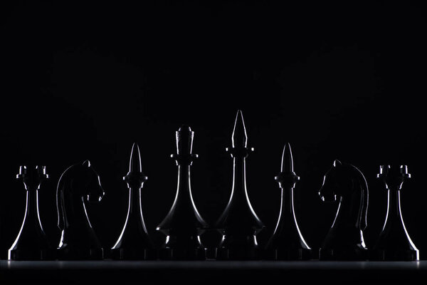 silhouettes of chess figures isolated on black, business concept