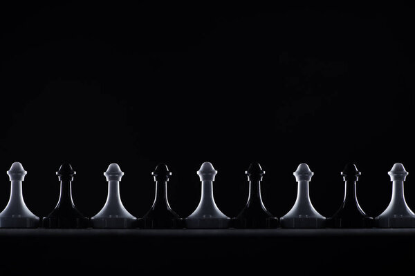 силуэты черно-белых шахматных пешек, изолированных на черном, бизнес-концепция

