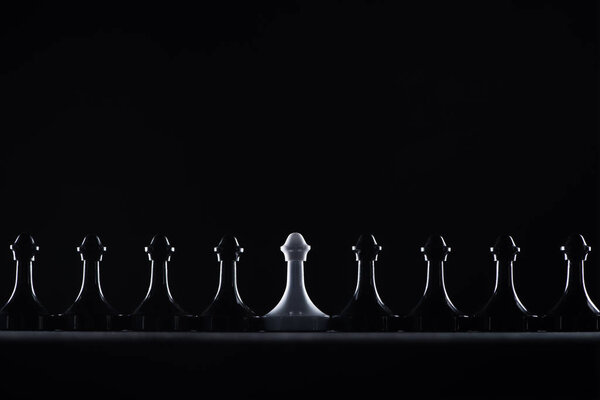 силуэты черно-белых шахматных пешек, изолированных на черном, бизнес-концепция
