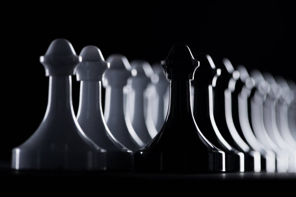 ряды белых и черных шахматных фигур, изолированных по черной, бизнес-концепции
