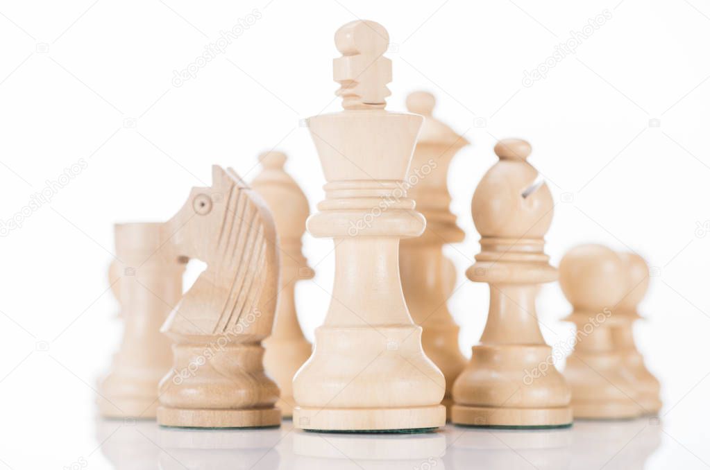 white wooden chess king with knight and bishop on sides on white 