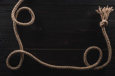 koyu ahşap yüzeyde bir düğüm ile kahverengi deniz ip Üstten Görünüm