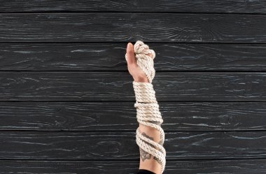 Kısmi Deniz ip ile el görünümünü koyu ahşap yüzey üzerinde