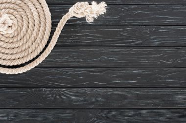 top view of white marine rope arranged in circle on dark wooden tabletop clipart