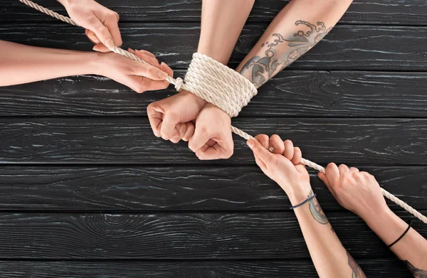 Visão Parcial Mulheres Amarrando Corda Torno Mãos Masculinas Mesa Madeira — Fotos gratuitas