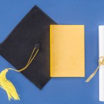 Sombrero de graduación con diploma y libro aislado en azul